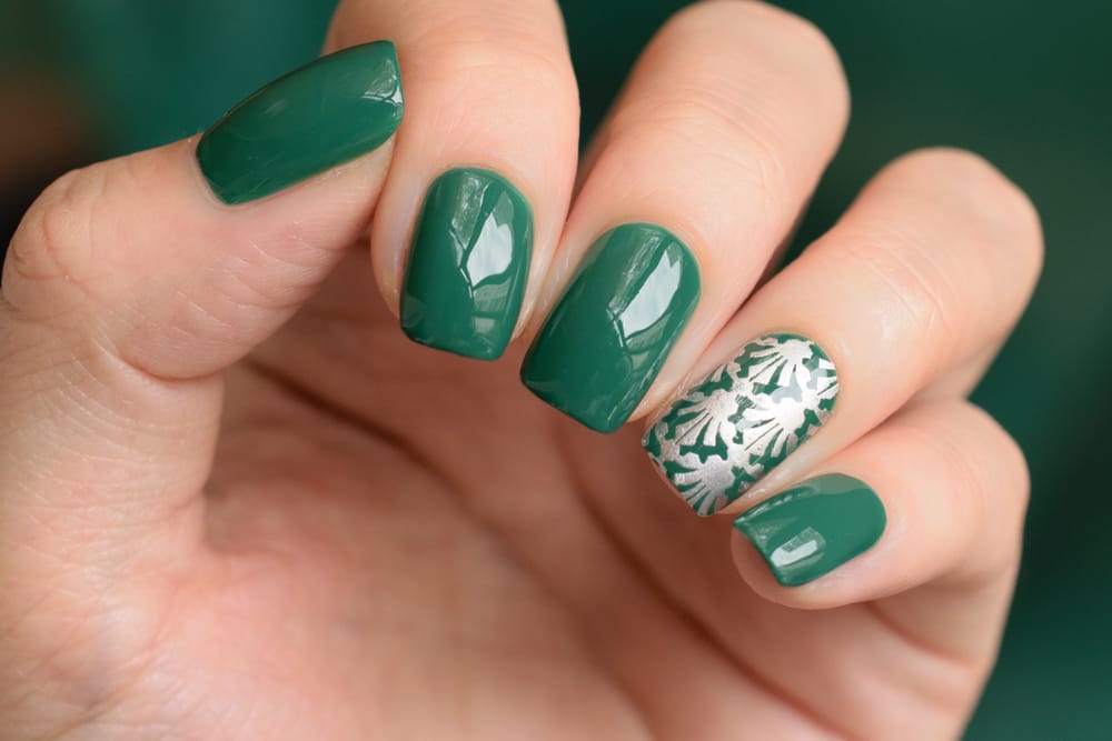 a hand with green painted fingernails