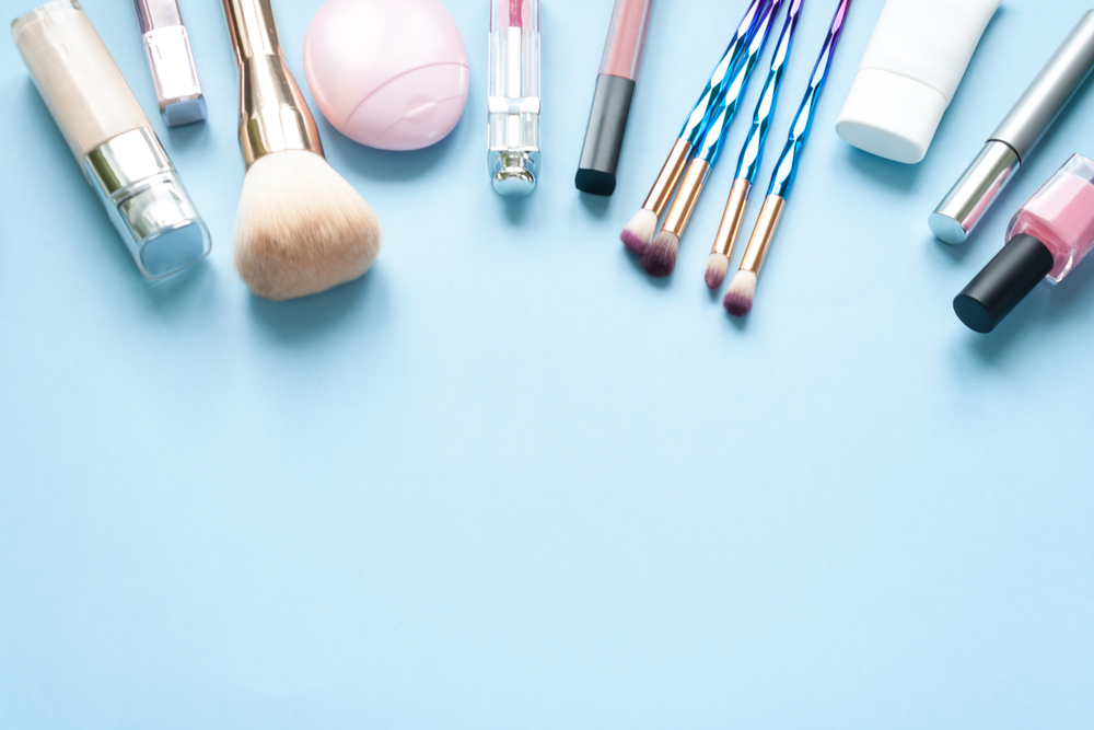 a group of makeup brushes and a bottle of cream