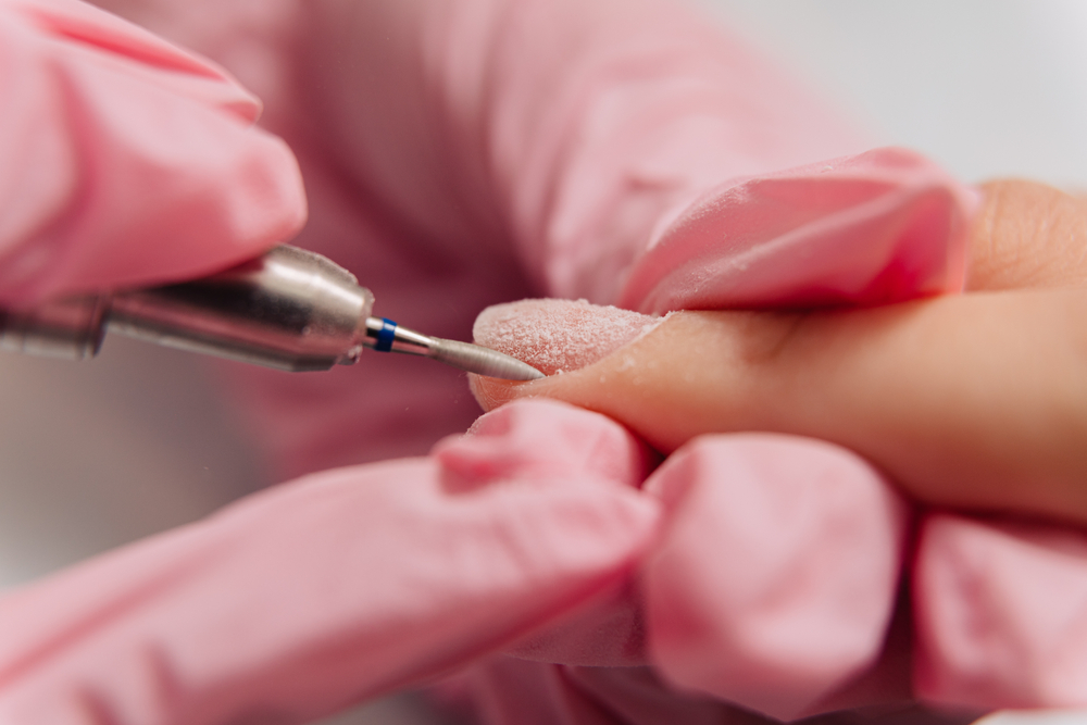 a person using a machine to remove a nail